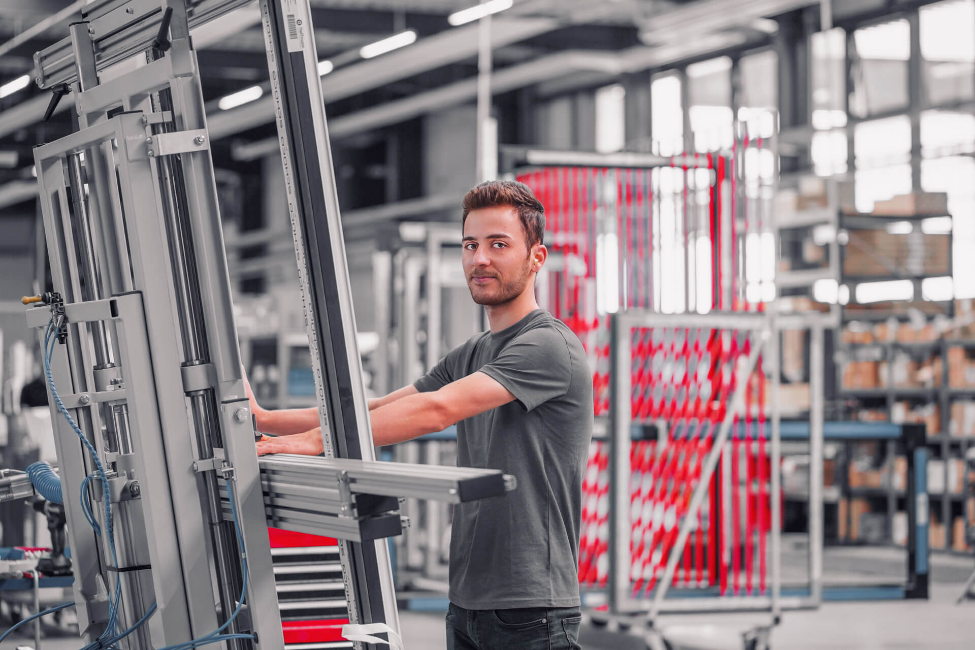 Fenster Hoffmann Mitarbeiter in der Produktionshalle schaut in die Kamera.